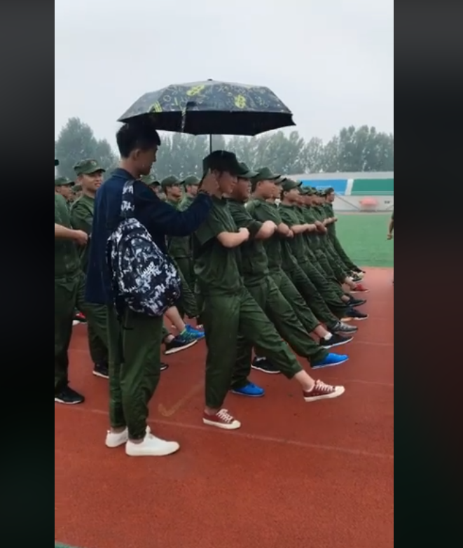 cầm ô che cho bạn gái, xôn xao clip chàng trai che ô cho bạn gái tập quân sự